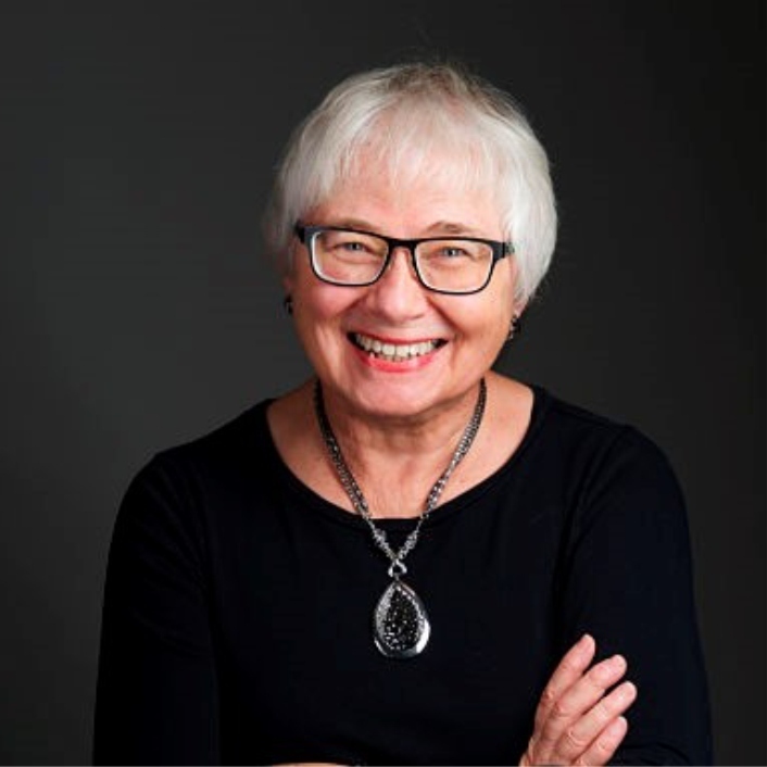 Beautiful smiling silver-haired woman wearing black on a black backdrop