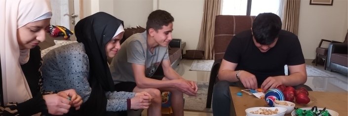 Four Syrian youth sitting in livingroom visiting