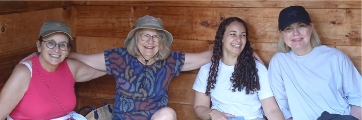 A group of four women laughing together.