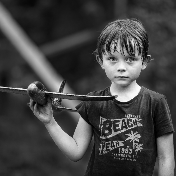 black and white photo of a young boy holding a toy airplane in his hand