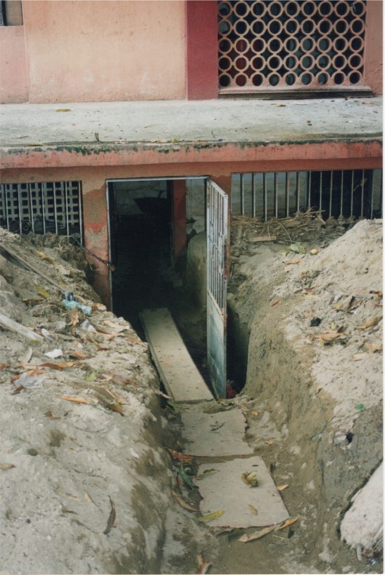 A path through dried mud and debris from a first-floor apartment building