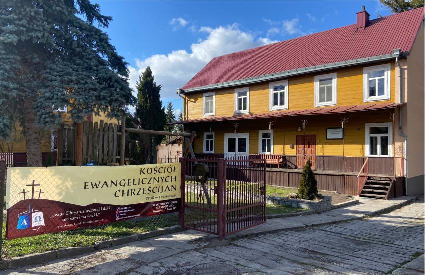 Two-story redbrown brick church with large sign out front