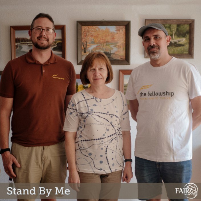 A woman standing in between two men posing for picture.