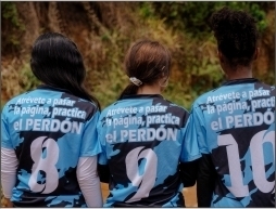 Three female Colombia soccer players in blue shirts