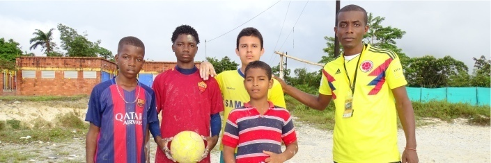 Boys and soccer coach pose for a photo